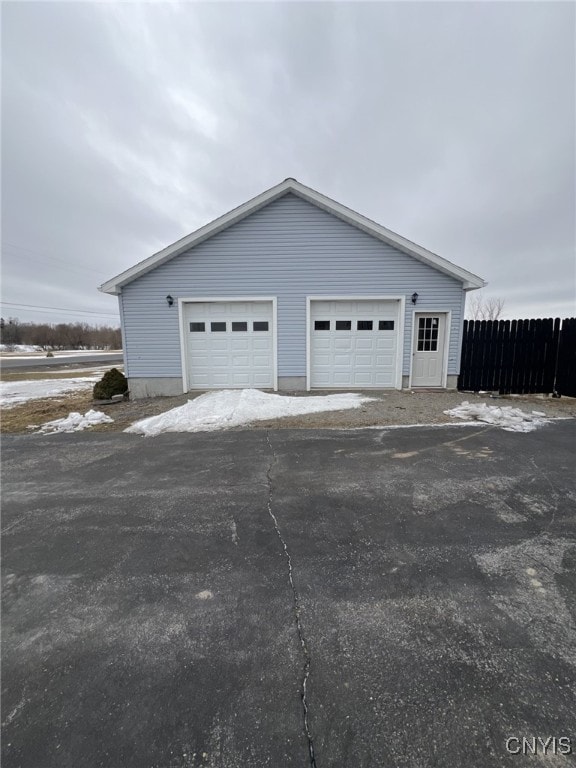 detached garage featuring fence