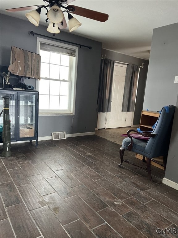 sitting room with a ceiling fan, visible vents, and baseboards