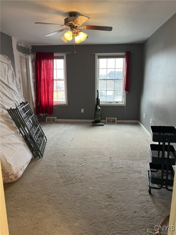 interior space featuring ceiling fan, visible vents, and baseboards