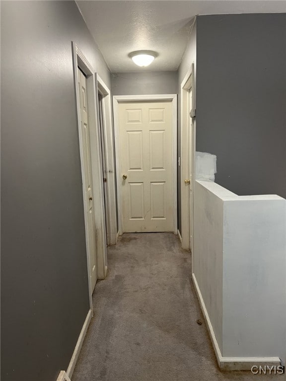 hallway featuring carpet floors and baseboards