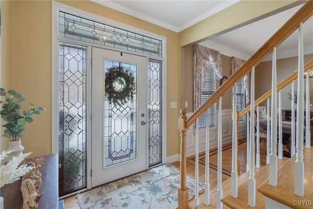 foyer entrance with baseboards, stairway, crown molding, and wood finished floors