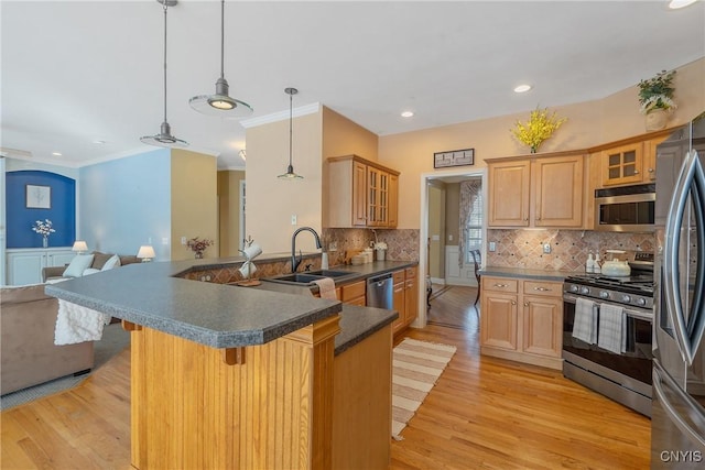 kitchen with a breakfast bar area, stainless steel appliances, a sink, open floor plan, and dark countertops