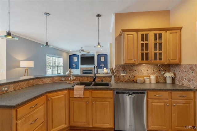 kitchen featuring a sink, stainless steel dishwasher, backsplash, dark countertops, and pendant lighting