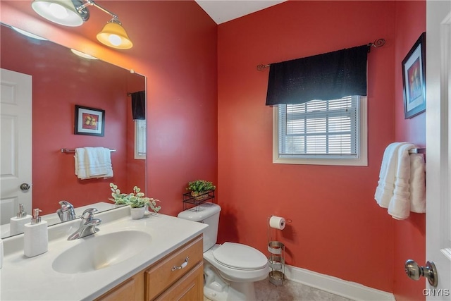 half bathroom with toilet, baseboards, and vanity