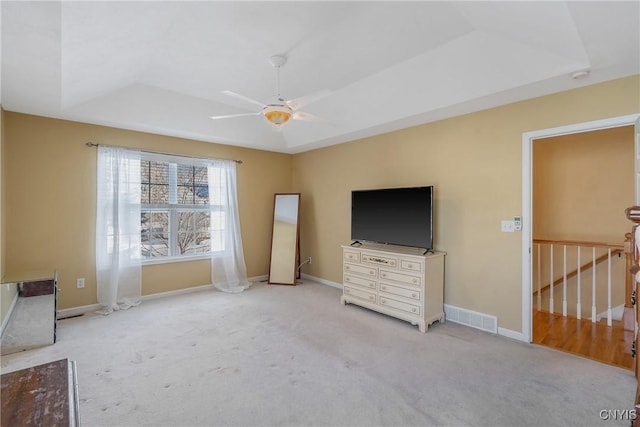 unfurnished bedroom with carpet, a raised ceiling, visible vents, and baseboards