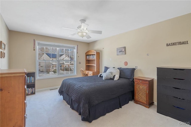 bedroom with light carpet, ceiling fan, and baseboards