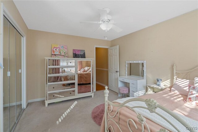 bedroom featuring a ceiling fan, baseboards, a closet, and light colored carpet