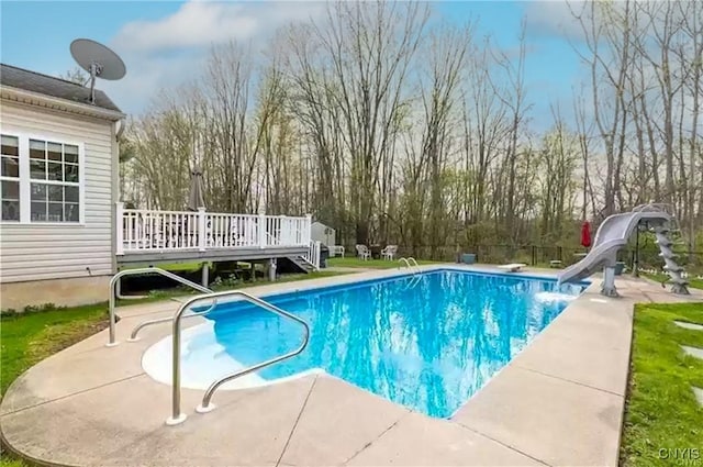 pool with a deck, a patio, and a water slide