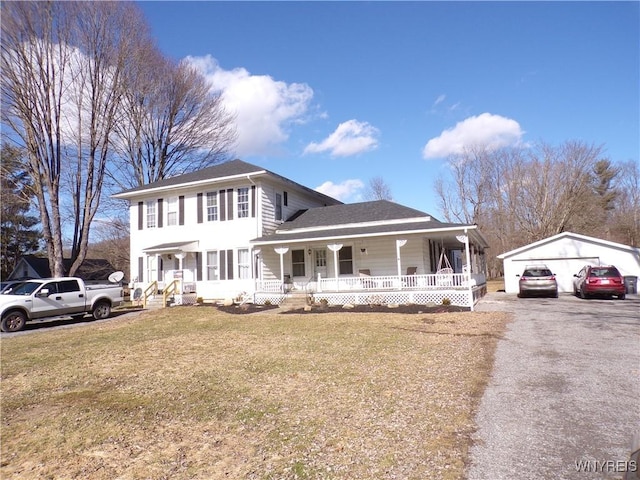 view of front of home with a porch, an outbuilding, a detached garage, and a front yard