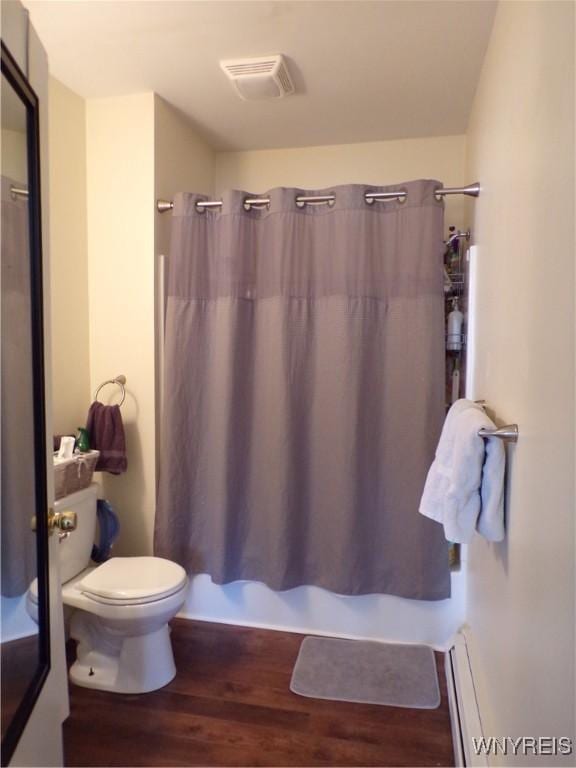 bathroom featuring a baseboard radiator, visible vents, toilet, shower / bath combo, and wood finished floors