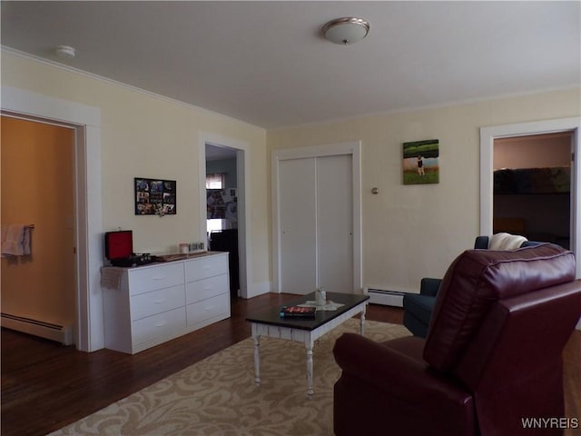 living area with ornamental molding, dark wood-type flooring, and baseboard heating