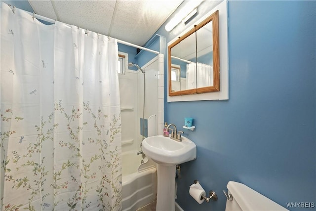 bathroom featuring toilet and shower / bath combination with curtain