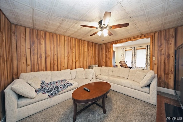 living area featuring an ornate ceiling, wooden walls, and ceiling fan