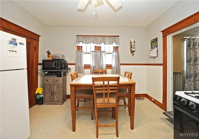 dining space with a ceiling fan and baseboards