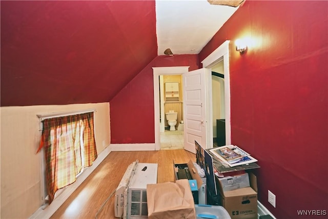 additional living space with lofted ceiling, wood finished floors, and baseboards