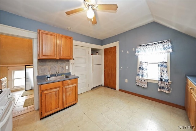 kitchen featuring a wealth of natural light, freestanding refrigerator, range, and dark countertops