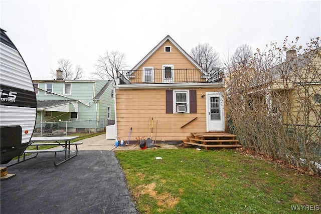 rear view of house featuring a yard, a patio area, fence, a balcony, and cooling unit