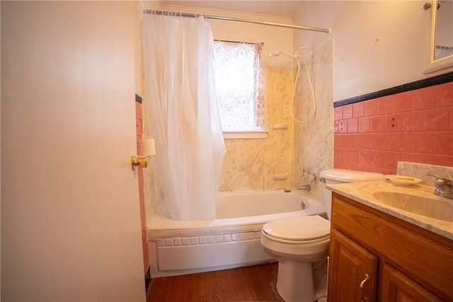 full bath featuring toilet, wood finished floors, shower / tub combo with curtain, vanity, and tile walls