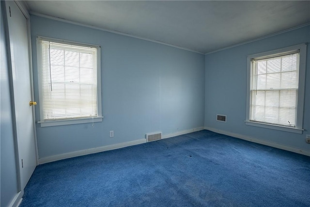 spare room featuring ornamental molding, carpet flooring, visible vents, and baseboards