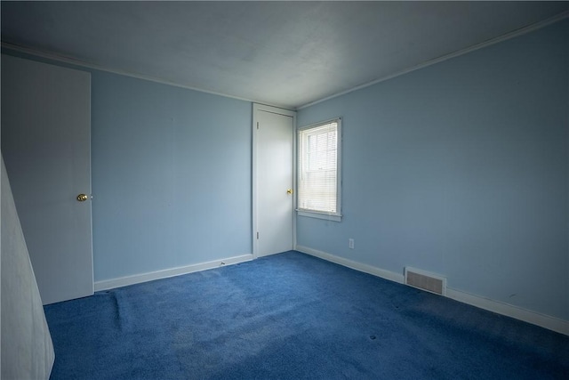 spare room with carpet floors, visible vents, and baseboards