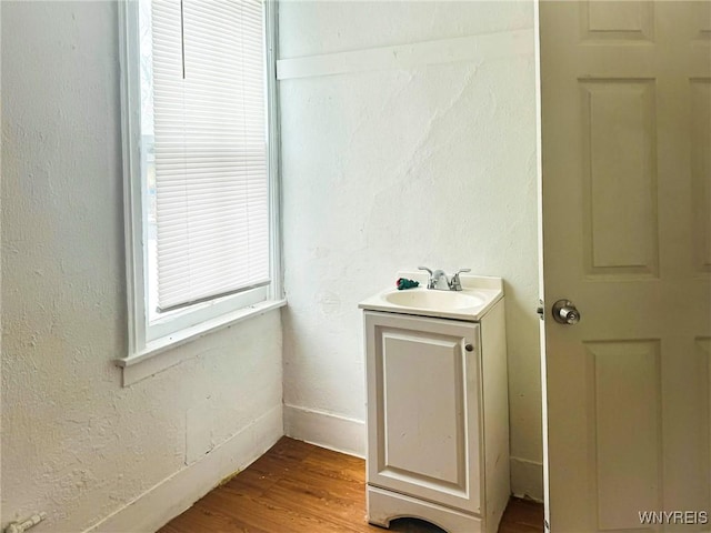 bathroom featuring a textured wall, wood finished floors, and vanity