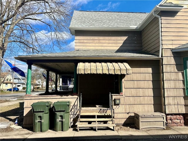 view of side of property featuring roof with shingles