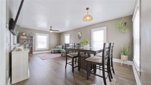 dining room with a ceiling fan, baseboards, and wood finished floors