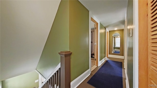 hallway featuring baseboards and an upstairs landing