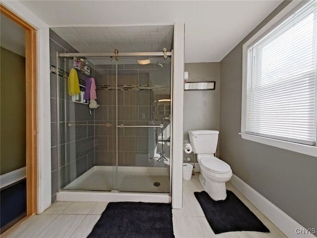 bathroom featuring a stall shower, tile patterned flooring, and toilet