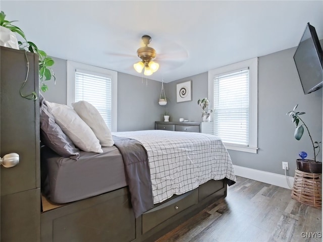 bedroom with a ceiling fan, baseboards, and wood finished floors