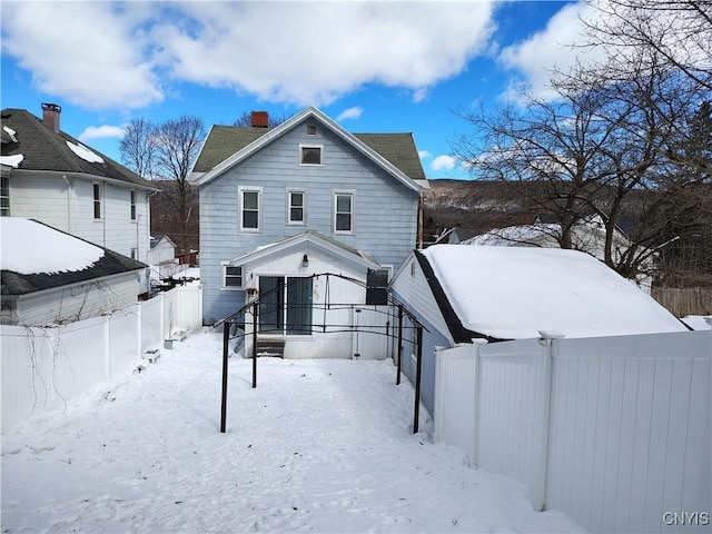 snow covered property with fence