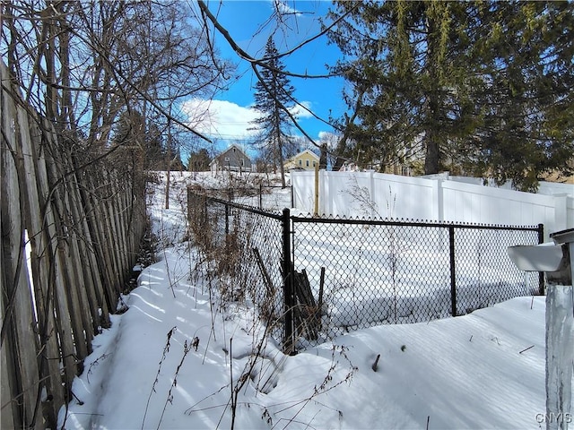 yard covered in snow featuring a fenced backyard