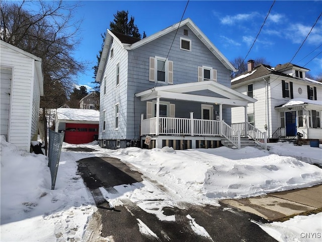 american foursquare style home with covered porch and an outdoor structure