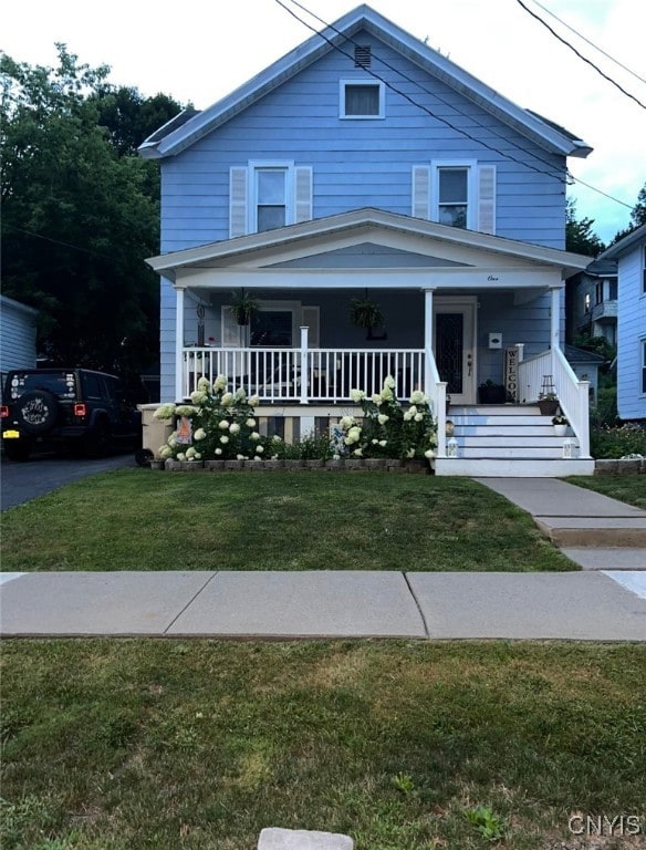 view of front of property with covered porch and a front lawn