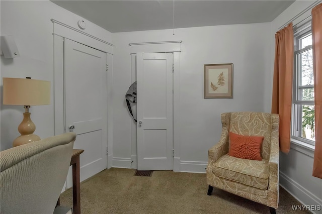 living area featuring carpet flooring and baseboards