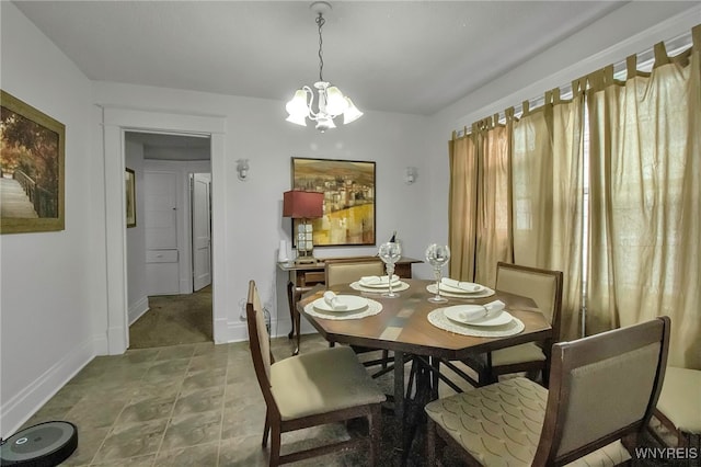 dining room with baseboards and an inviting chandelier