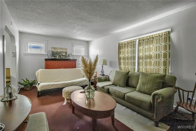 carpeted living area featuring arched walkways and a textured ceiling