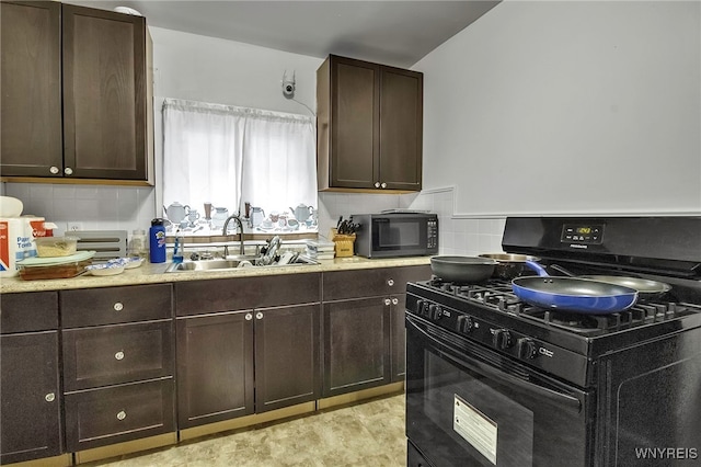 kitchen featuring black appliances, tasteful backsplash, dark brown cabinets, and a sink