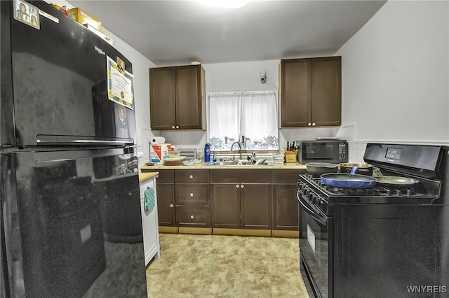 kitchen featuring black appliances, a sink, light countertops, and dark brown cabinetry