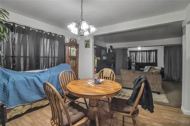 dining area with wood finished floors and an inviting chandelier