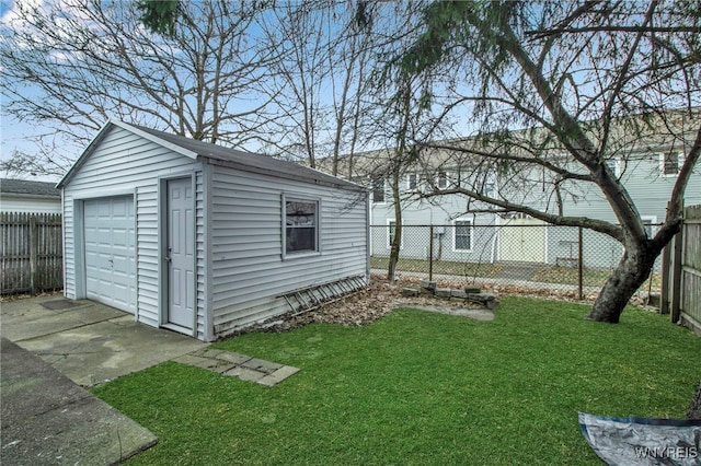 view of yard with a detached garage, fence, and an outdoor structure