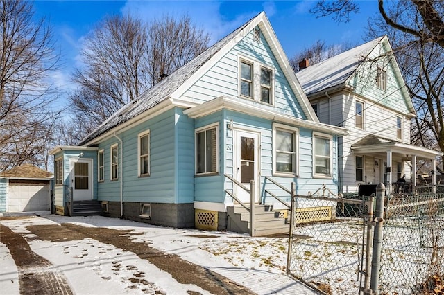 view of front of house featuring entry steps, fence, a garage, driveway, and an outdoor structure