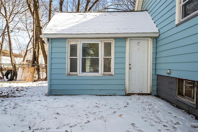 snow covered property entrance with fence