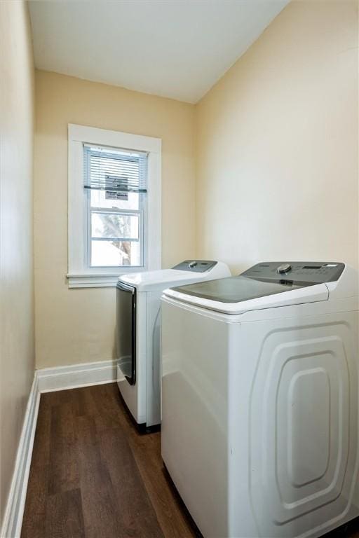 laundry area featuring laundry area, washing machine and dryer, baseboards, and dark wood-type flooring