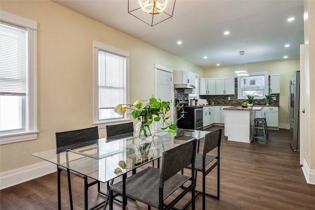 dining space featuring baseboards, dark wood finished floors, and a wealth of natural light