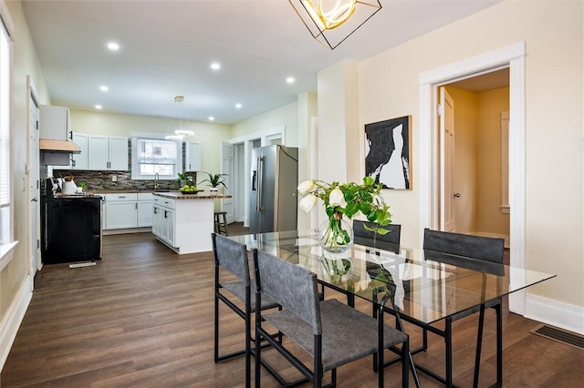 dining room with dark wood-style floors, baseboards, visible vents, and recessed lighting