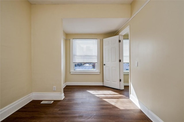 interior space with wood finished floors, visible vents, and baseboards