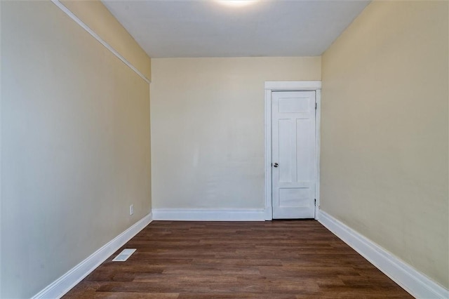 spare room with visible vents, dark wood finished floors, and baseboards