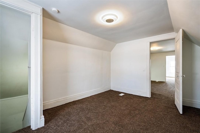 bonus room featuring lofted ceiling, baseboards, and dark colored carpet