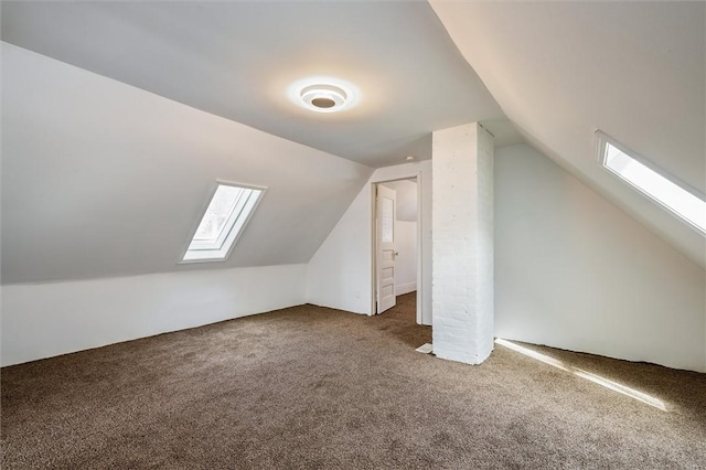 additional living space with vaulted ceiling with skylight and carpet